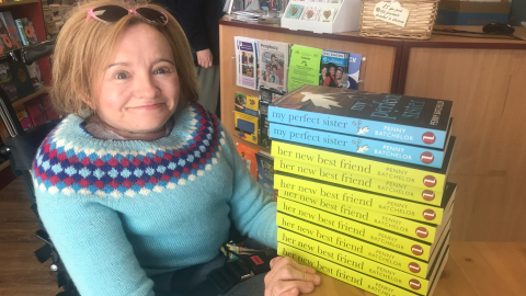 The image shows Penny Batchelor with a stack of her books titled 'My Perfect Sister' and 'Her new best friend'.